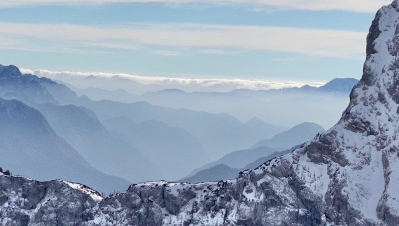 Craggy mountains in forground with layers of misty peaks into distance
